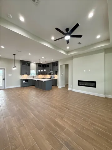 a view of kitchen and kitchen with stainless steel appliances wooden floor
