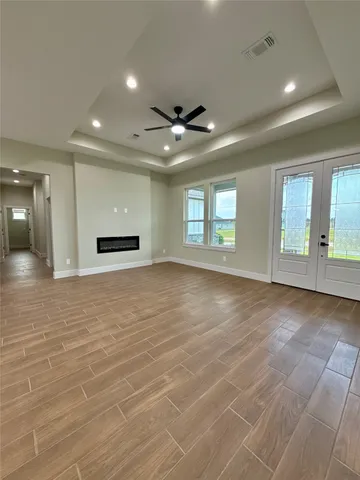 an empty room with wooden floor and windows