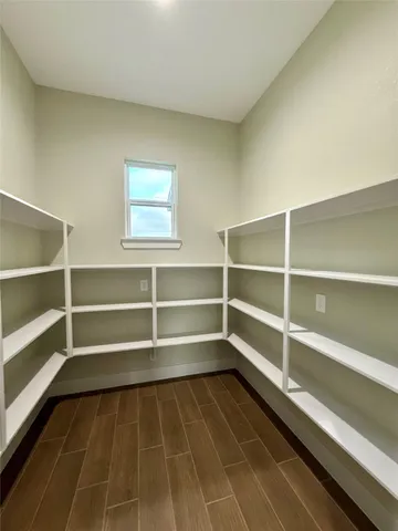 a room with walk in closet and wooden floor