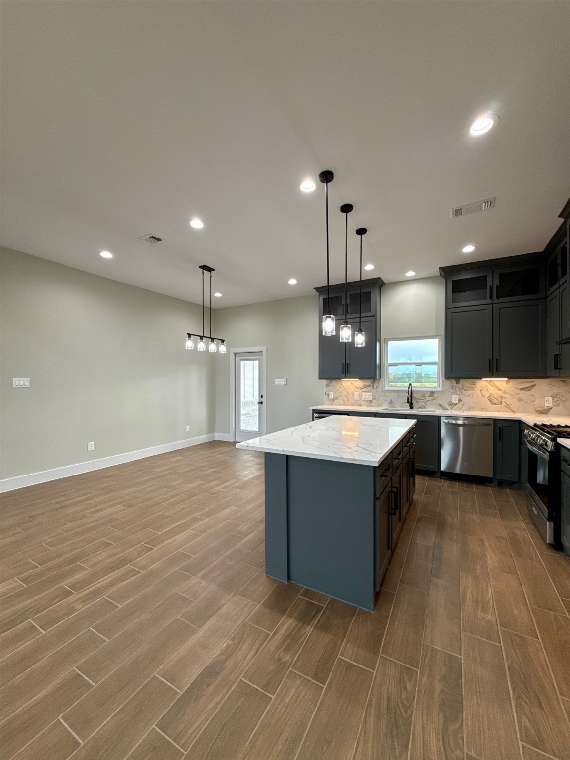 925 Buffalo Trail Angleton, TX 77515 - Photo 7 of 19 a large kitchen with stainless steel appliances a large counter top a stove and a sink