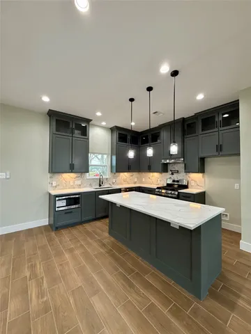 a large kitchen with a large counter top appliances and cabinets