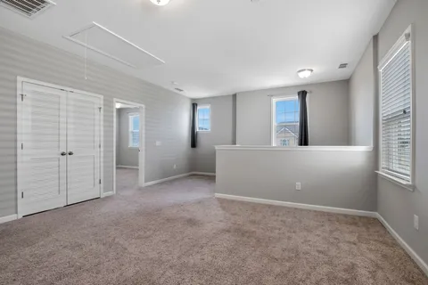 an empty room with windows and closet