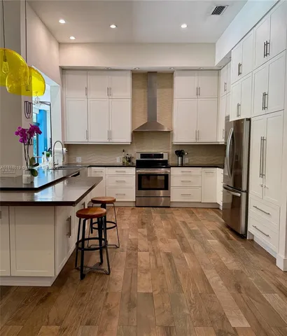 a kitchen with stainless steel appliances granite countertop a stove a refrigerator and a sink