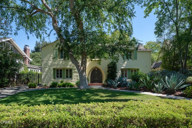 a front view of a house with a garden and plants