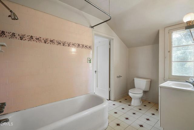 a bathroom with a sink a toilet a window and a shower