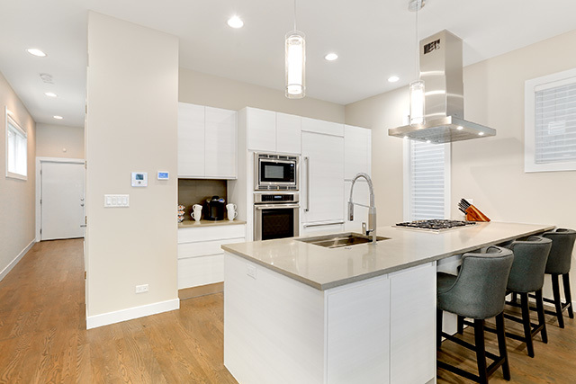 2042 West Rice Street, Unit 1 Chicago, IL 60622 - Photo 6 of 27 a kitchen with a table chairs refrigerator and microwave