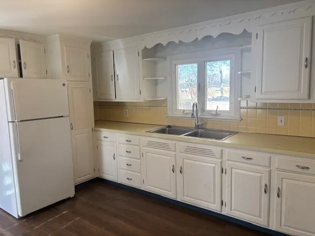 a kitchen with granite countertop white cabinets and white appliances