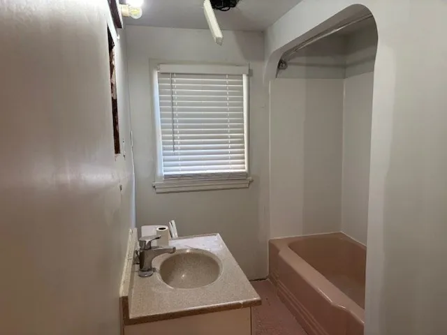 a bathroom with a sink a window and tub