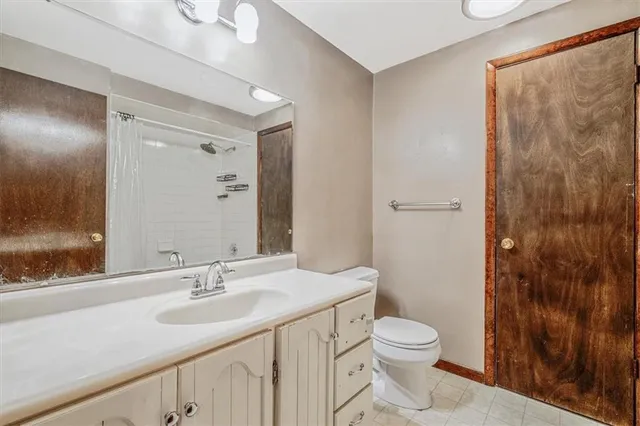 a bathroom with a toilet a sink a mirror and a shower