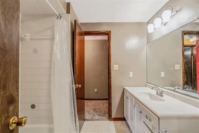 a spacious bathroom with a double vanity sink a mirror and shower