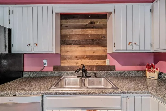 a kitchen with granite countertop a sink and cabinets