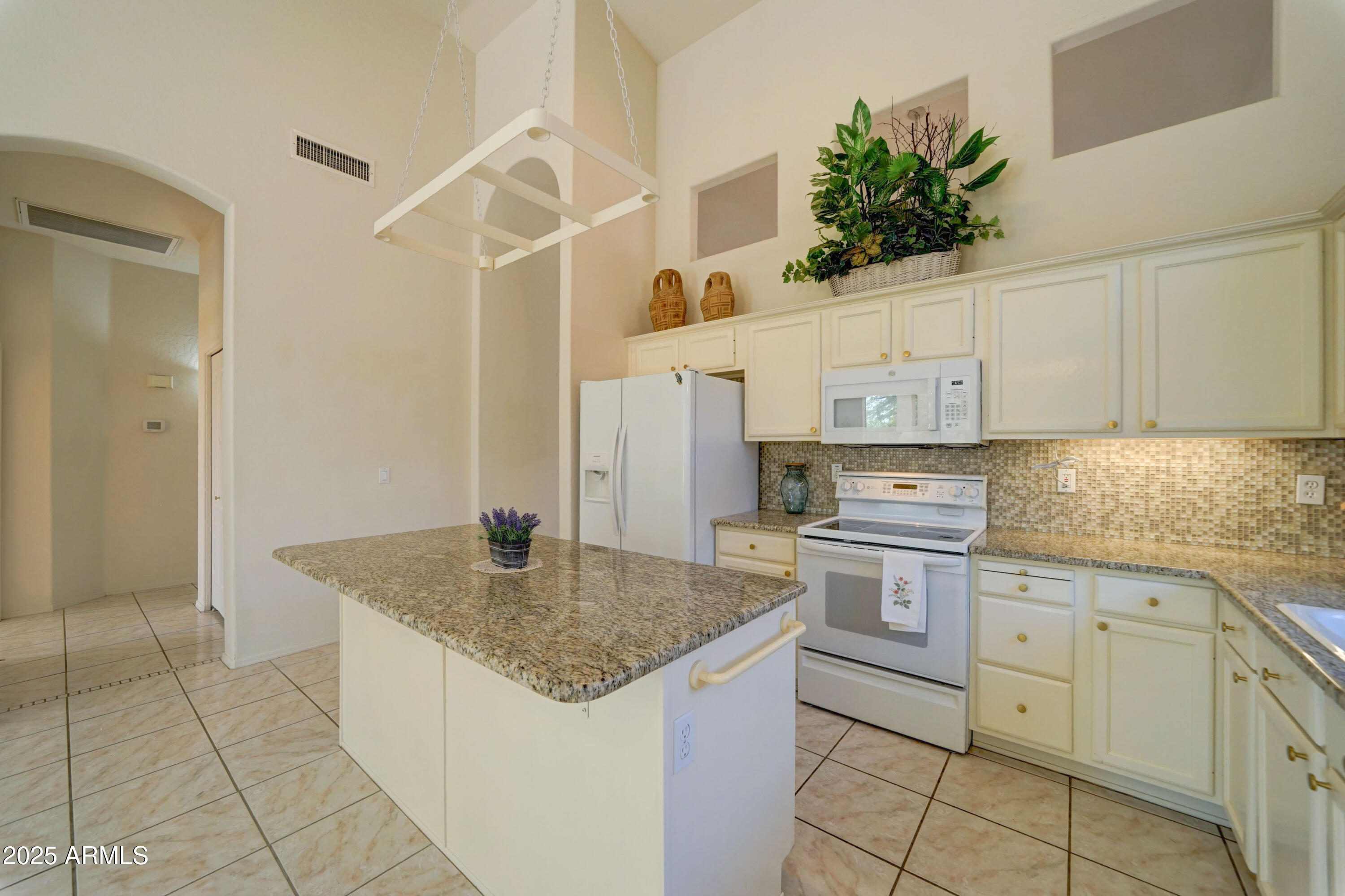 3055 North Red Mountain, Unit 74 Mesa, AZ 85207 - Photo 16 of 38 a kitchen with stainless steel appliances granite countertop a sink and a refrigerator