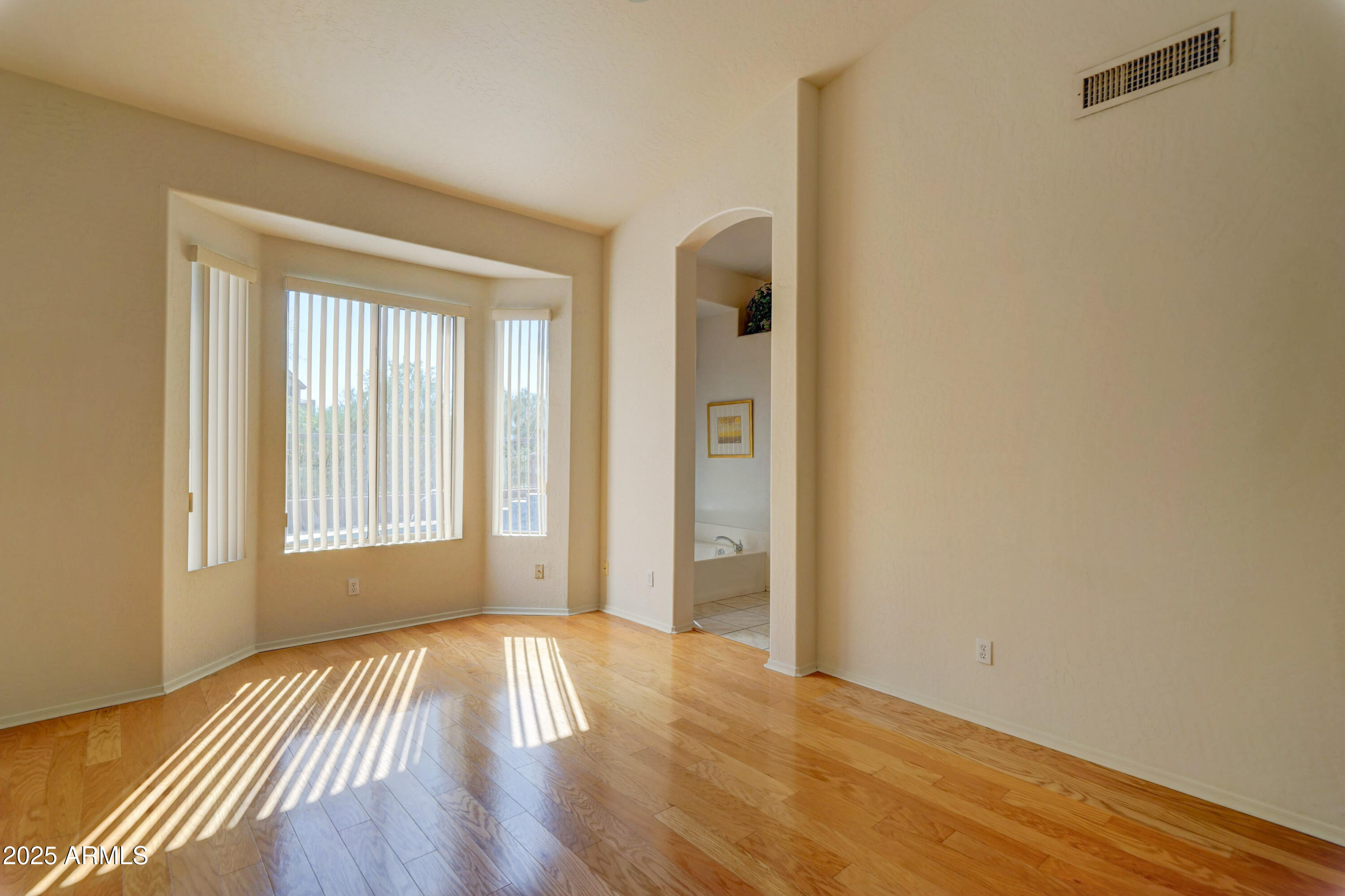 3055 North Red Mountain, Unit 74 Mesa, AZ 85207 - Photo 19 of 38 a view of an empty room with wooden floor and a window