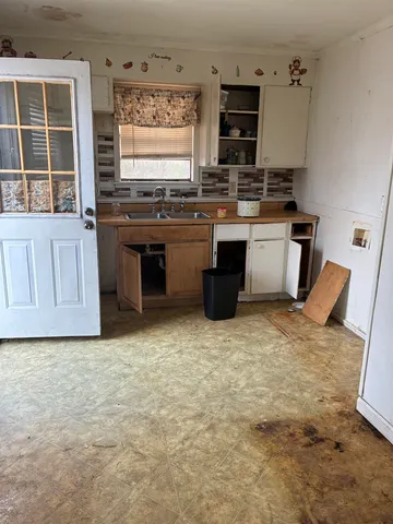 a kitchen with stainless steel appliances a stove top oven a sink a counter space and cabinets