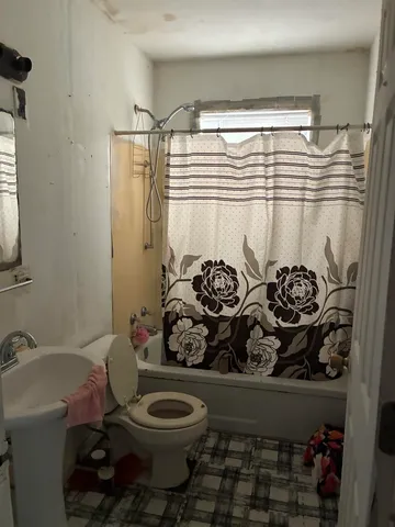 a bathroom with a toilet and a shower curtain
