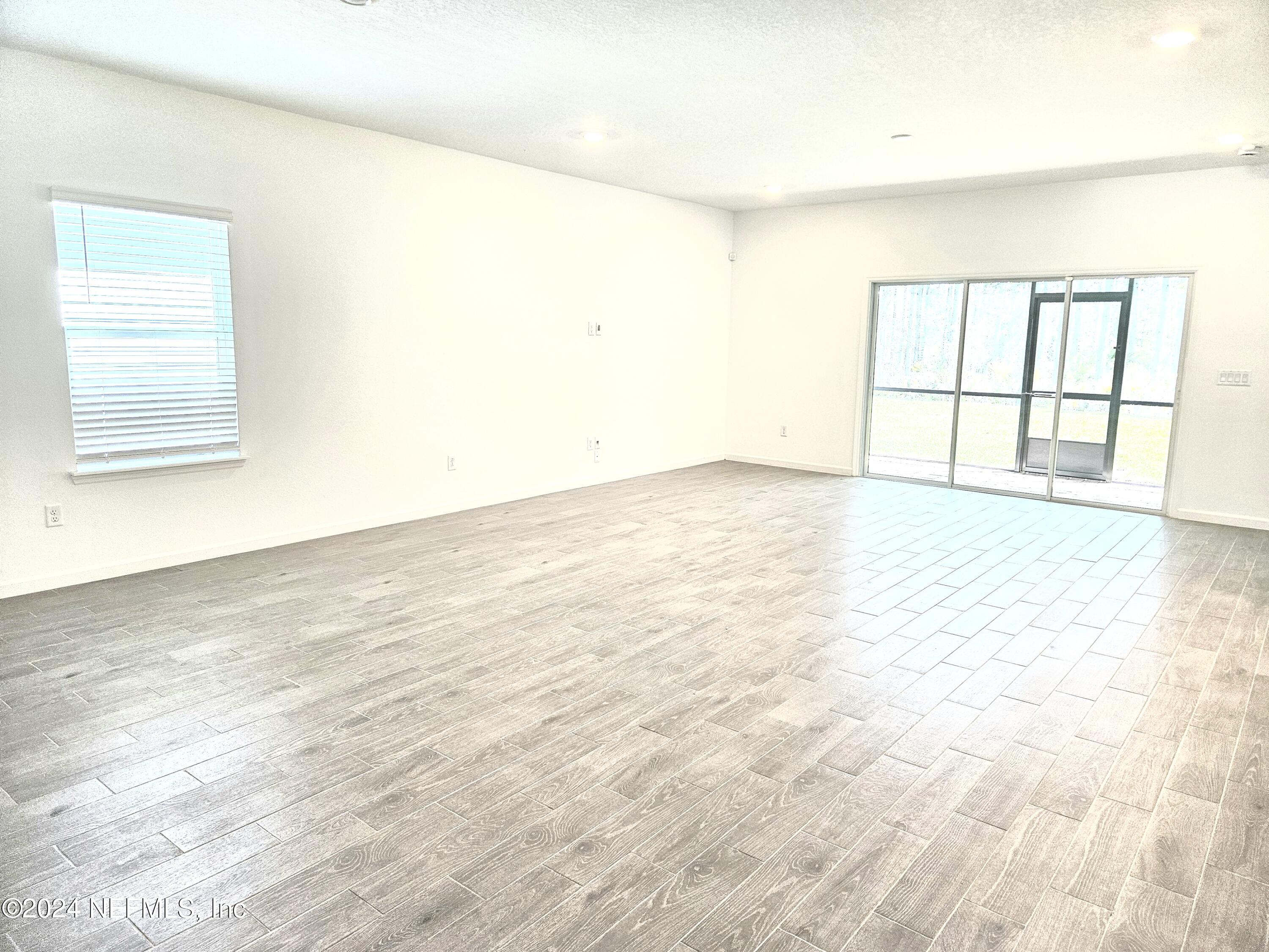 49 Blue Cypress Trail St. Augustine, FL 32084 - Photo 11 of 23 an empty room with wooden floor and windows