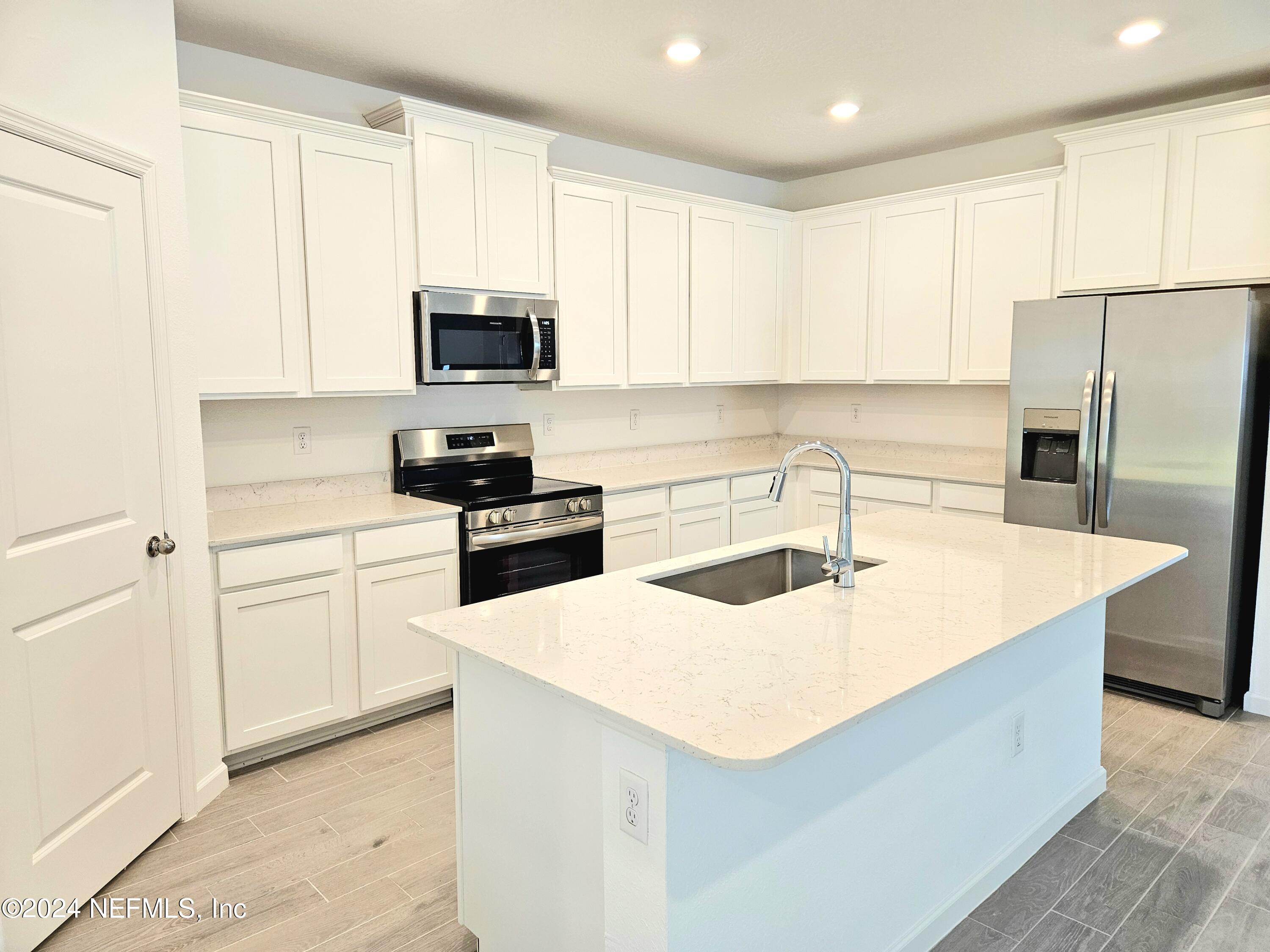 49 Blue Cypress Trail St. Augustine, FL 32084 - Photo 5 of 23 a kitchen with granite countertop a sink a counter top space stainless steel appliances and cabinets