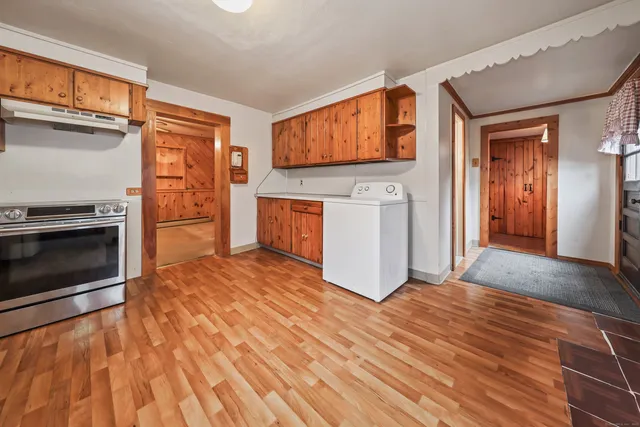 a kitchen with wooden floors and wooden cabinets