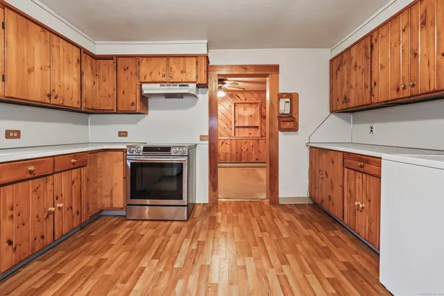 a view of a kitchen with wooden floor and electronic appliances