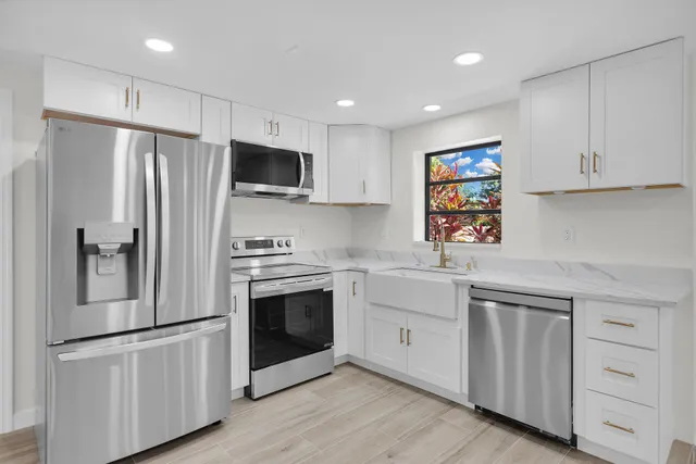 a sink with white cabinets and wooden floor