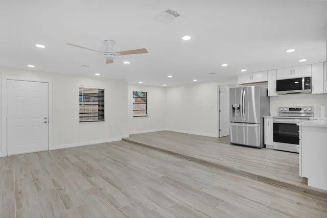 a view of kitchen with stainless steel appliances refrigerator oven and cabinets