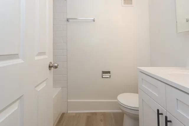 a bathroom with a granite countertop toilet and a shower