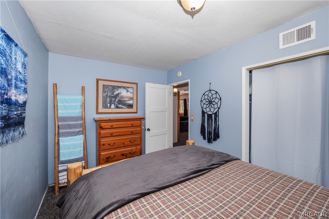 1099 Canyon Road Fawnskin, CA 92333 - Photo 20 of 39 a bedroom with a bed and painting on the wall