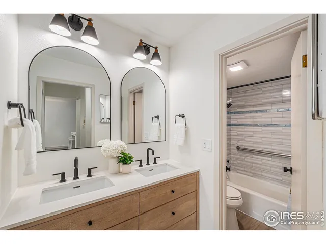 a bathroom with a double vanity sink and a mirror