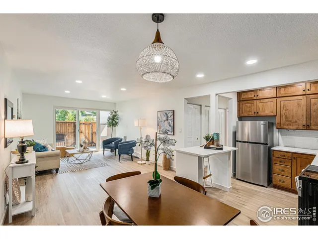 a living room with stainless steel appliances granite countertop furniture wooden floor and a view of kitchen