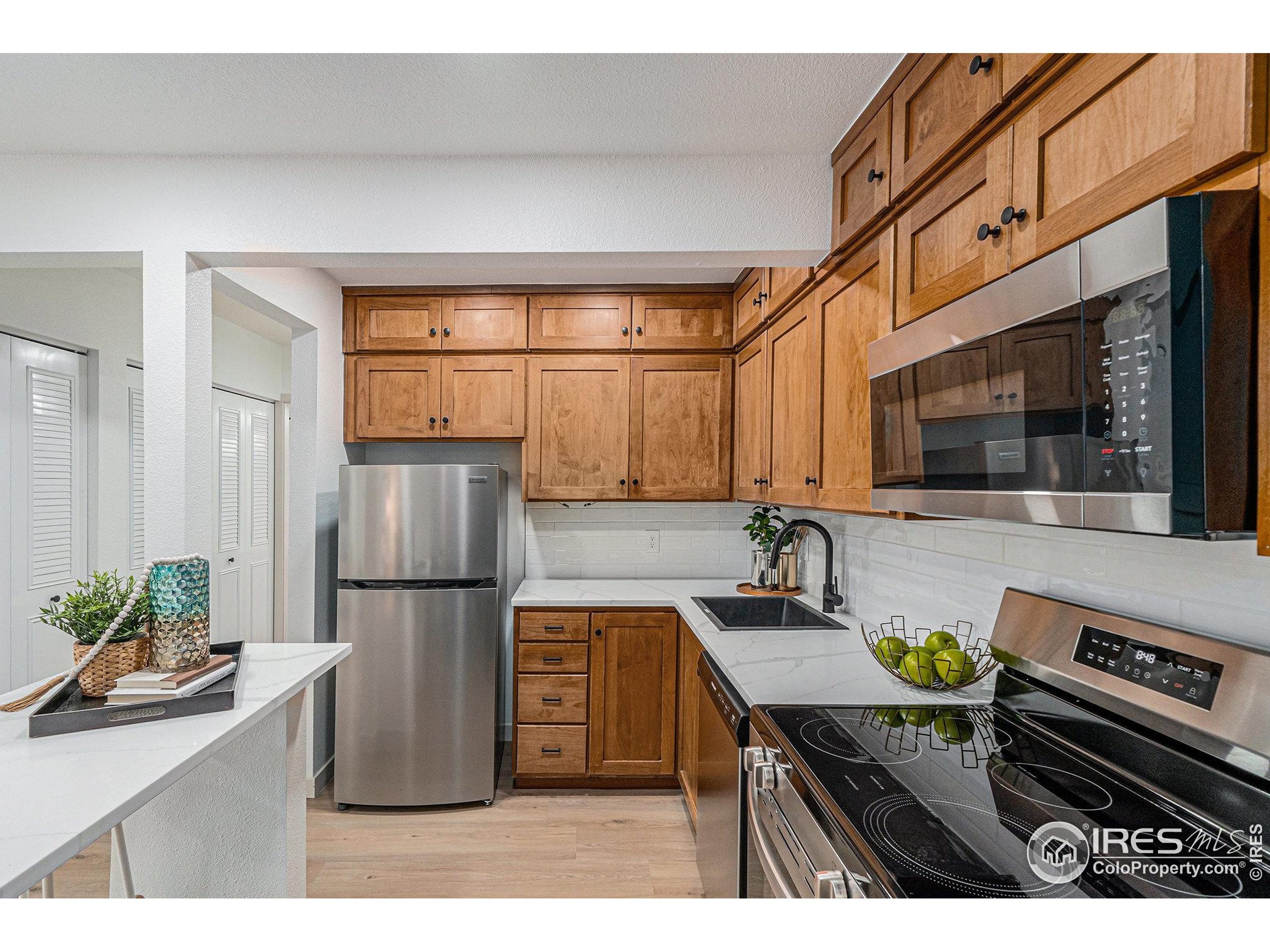 620 Mathews Street, Unit 104 Fort Collins, CO 80524 - Photo 5 of 32 a kitchen with a refrigerator and a sink