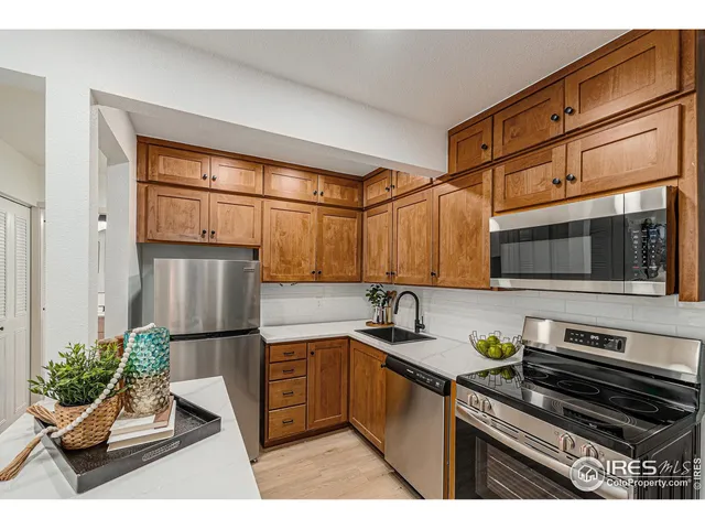 a kitchen with stainless steel appliances kitchen island granite countertop a sink and a refrigerator