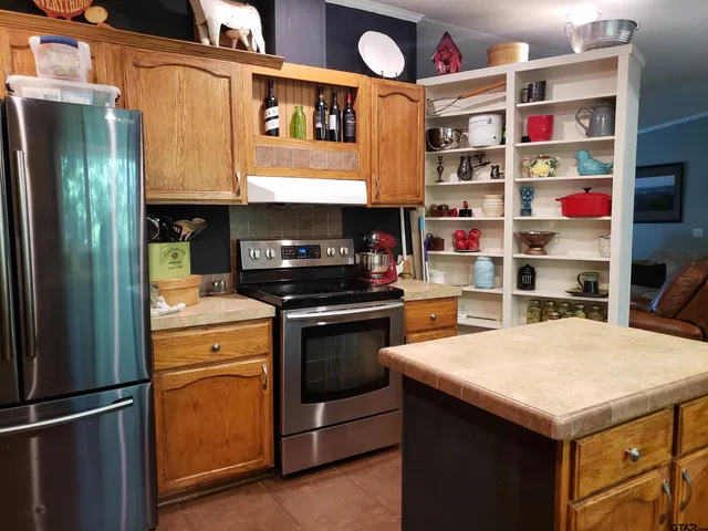 a kitchen with stainless steel appliances granite countertop a sink and a stove