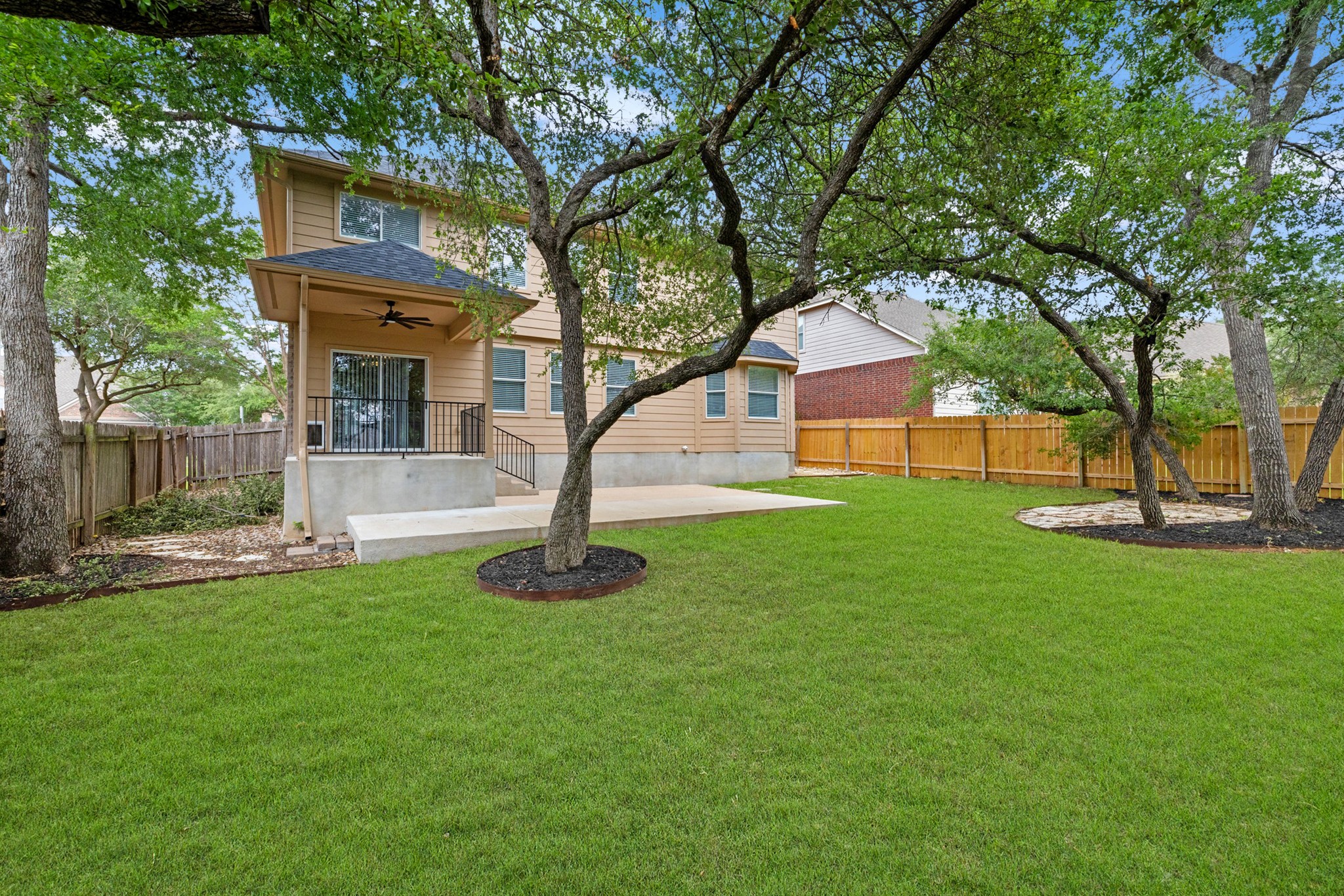 403 Red Hawk Drive Leander, TX 78641 - Photo 31 of 37 Expansive green lawn with mature trees and a wood privacy fence