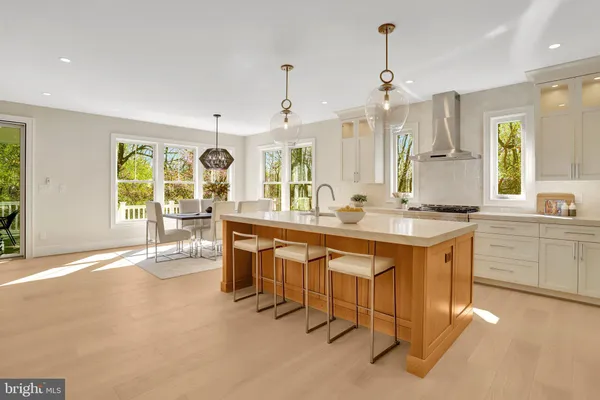 a kitchen with stainless steel appliances granite countertop a sink a stove a refrigerator and island with wooden floor