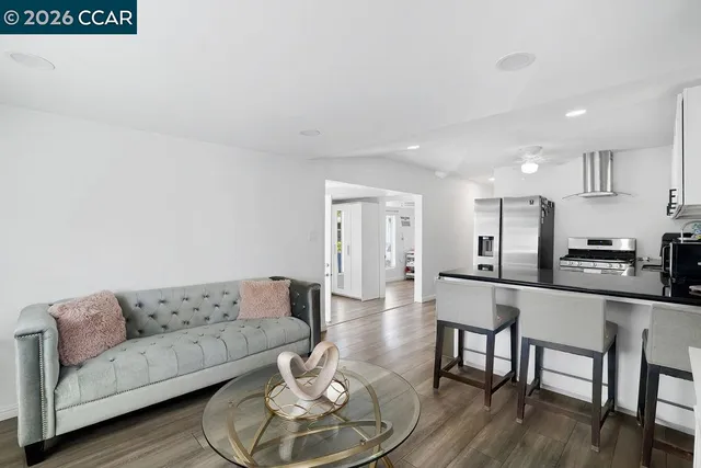a living room with furniture and kitchen view