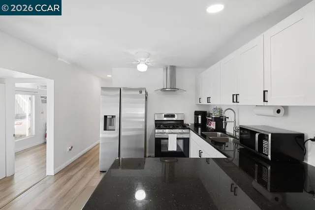 a kitchen with stainless steel appliances a stove a sink and a refrigerator