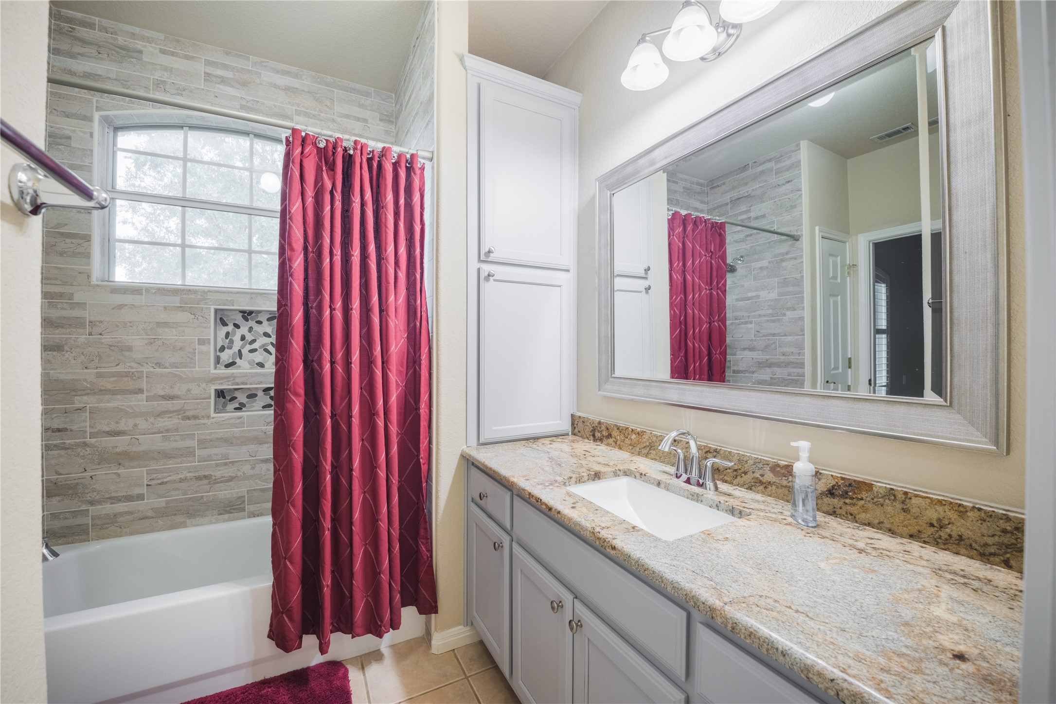 20145 Janak Road Coupland, TX 78615 - Photo 20 of 40 Granite counters and tiled shower surround create a refined bathing space in the Jack-n-Jill bathroom.