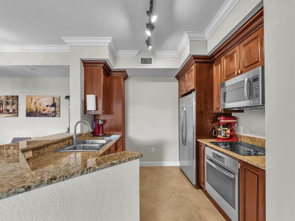 1660 Renaissance Commons Boulevard, Unit 2628 Boynton Beach, FL 33426 - Photo 21 of 49 a kitchen with stainless steel appliances granite countertop a sink stove and refrigerator