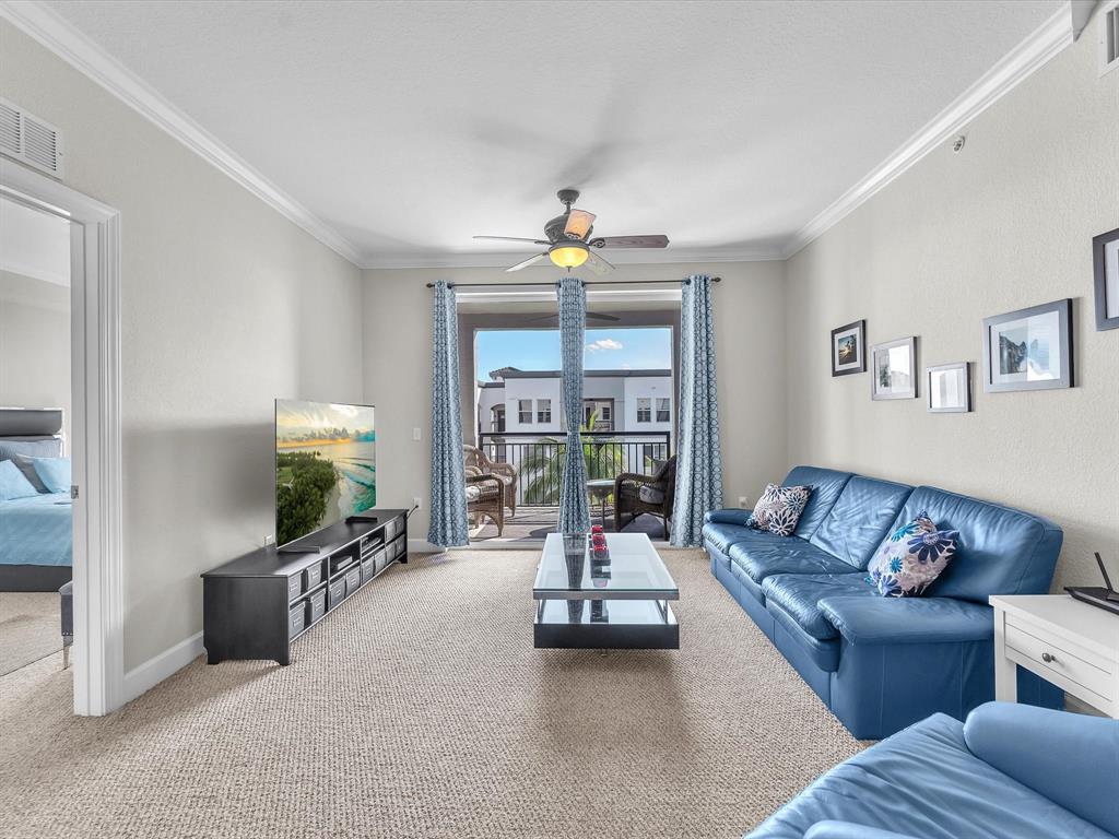 1660 Renaissance Commons Boulevard, Unit 2628 Boynton Beach, FL 33426 - Photo 3 of 49 a living room with furniture a flat screen tv and a large window