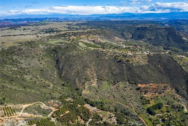 an aerial view of residential houses with outdoor space and trees