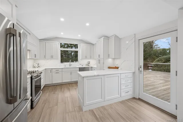 a kitchen with white cabinets and wooden floor