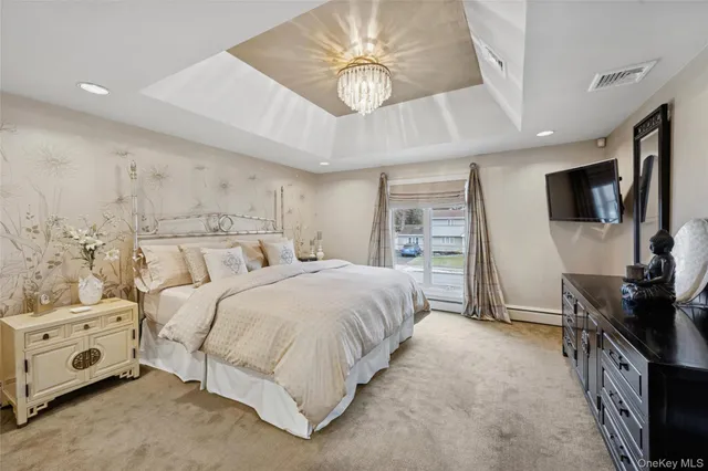 a spacious bedroom with a bed and a flat tv screen on the dresser