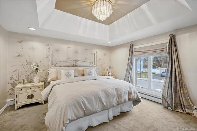 a bedroom with a bed a mirror and a large window