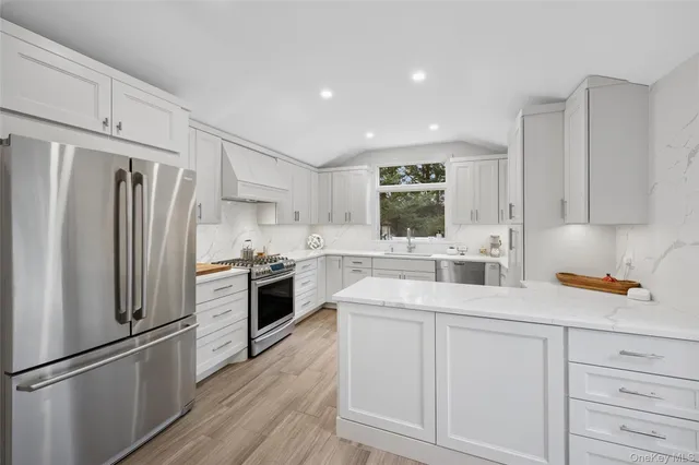 a kitchen with white cabinets and stainless steel appliances