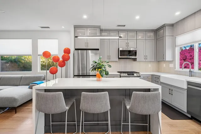 a kitchen with stainless steel appliances granite countertop a dining table and chairs