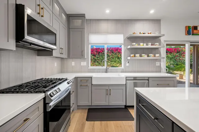 a kitchen that has a lot of cabinets in it and wooden floor