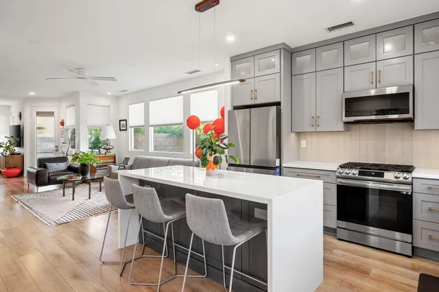 a kitchen with stainless steel appliances a stove a sink a microwave a refrigerator and cabinets