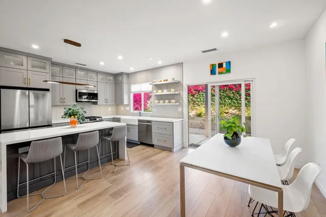 a kitchen with stainless steel appliances white cabinets and wooden floor