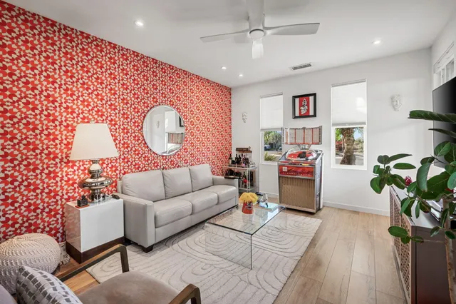 a living room with furniture a chandelier and a potted plant