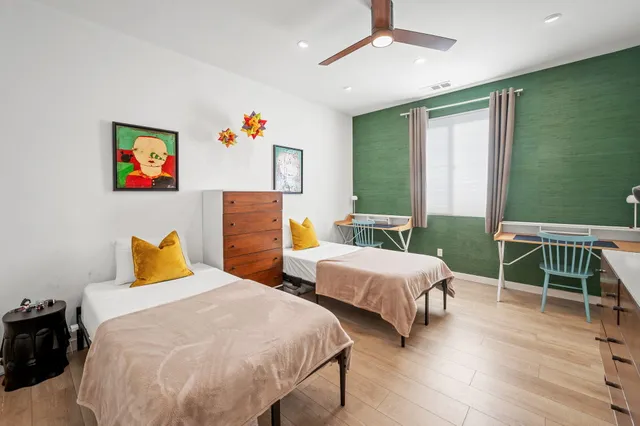 a bedroom with two beds and a wooden floor